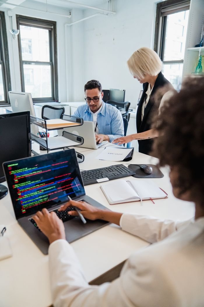 Home Team of professionals collaborating in a modern office, focused on coding and project management.